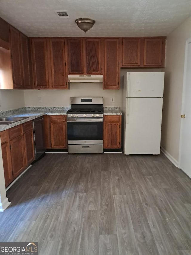 kitchen with dishwasher, white refrigerator, sink, stainless steel gas range, and a textured ceiling