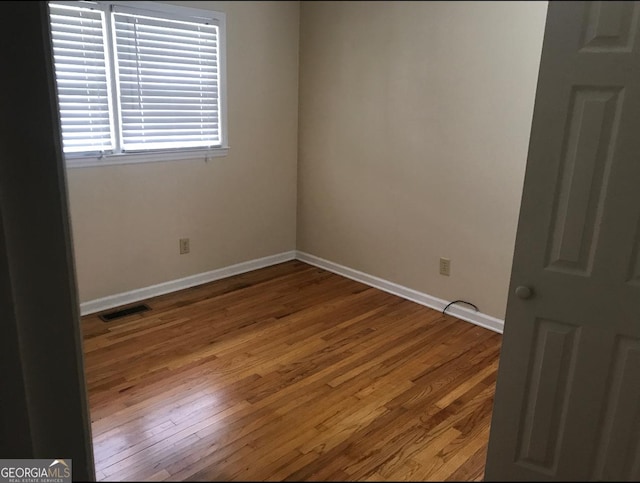 unfurnished room with hardwood / wood-style floors