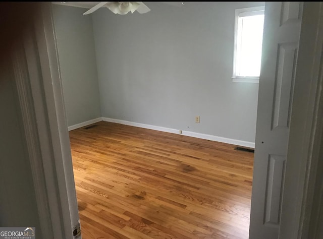 spare room with light wood-type flooring and ceiling fan