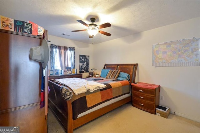 bedroom featuring a textured ceiling, carpet floors, and ceiling fan