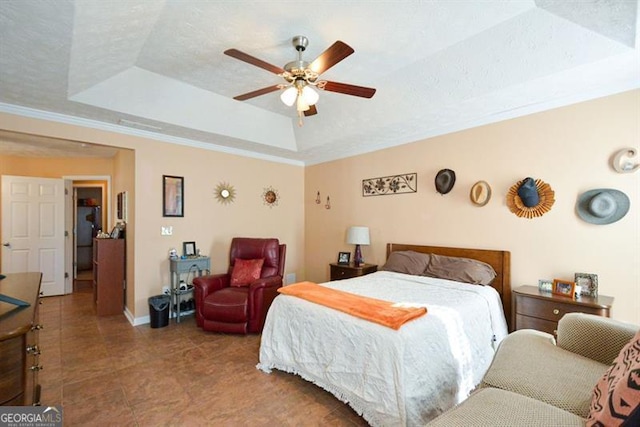 bedroom with a textured ceiling, a tray ceiling, ceiling fan, and crown molding