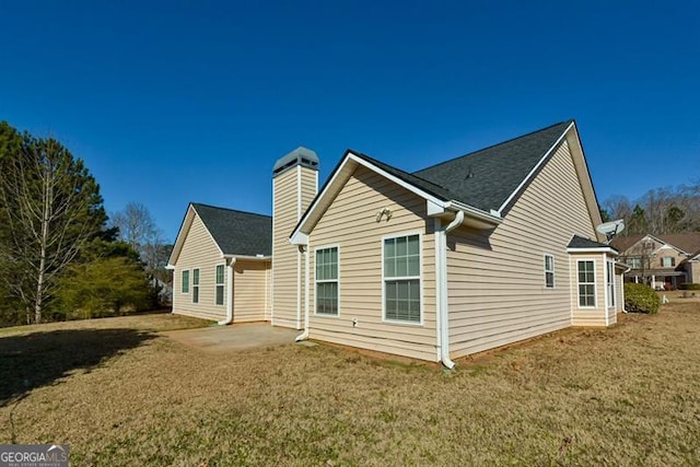 back of house with a yard and a patio