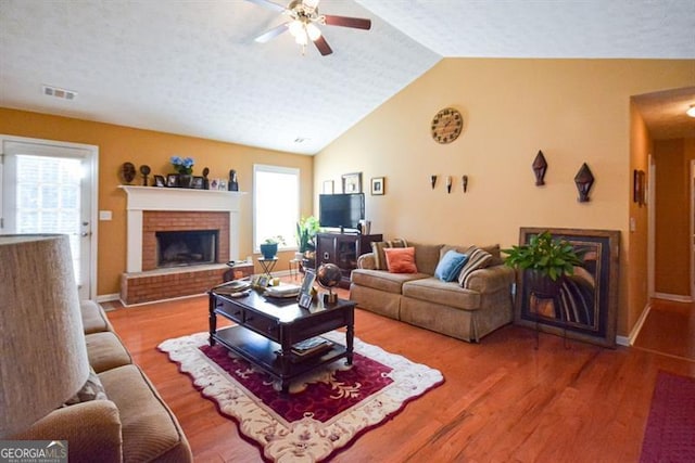 living room with hardwood / wood-style flooring, ceiling fan, a healthy amount of sunlight, and a textured ceiling