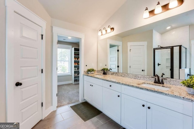 bathroom with tile patterned floors, vanity, vaulted ceiling, and an enclosed shower