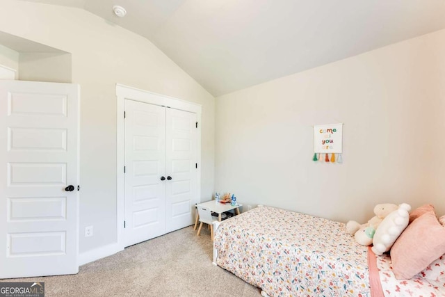 bedroom with a closet, light colored carpet, and vaulted ceiling