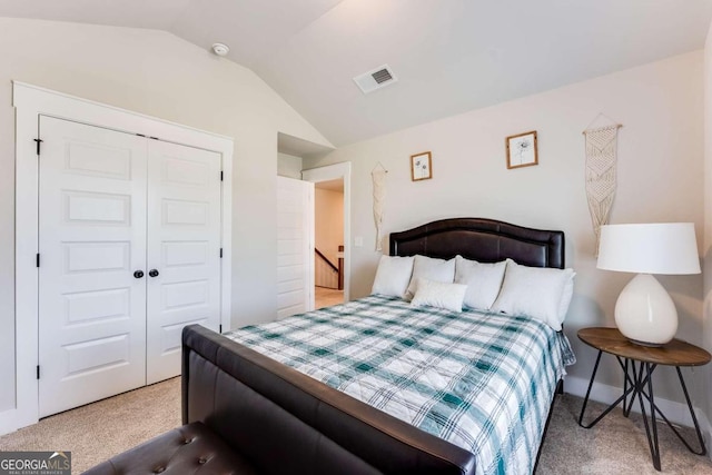 carpeted bedroom featuring a closet and lofted ceiling