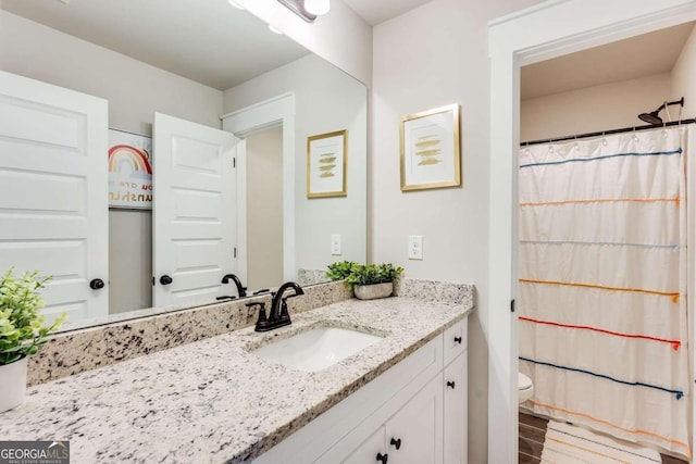 bathroom featuring vanity, toilet, and walk in shower