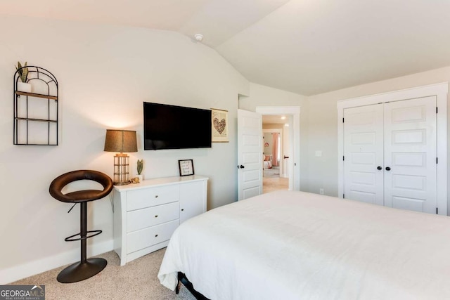 bedroom with light carpet, a closet, and lofted ceiling