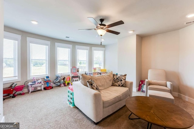 carpeted living room with ceiling fan