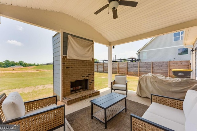 view of patio with an outdoor living space with a fireplace and ceiling fan