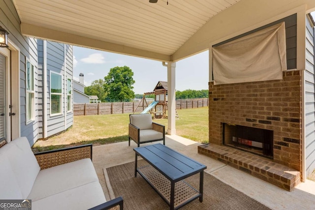 view of patio with a playground and an outdoor living space with a fireplace