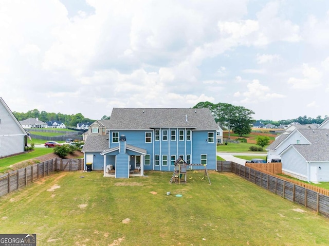 rear view of property with a yard