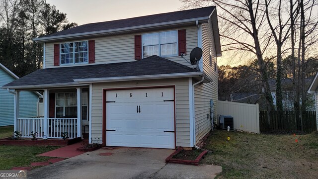 view of property featuring a porch, a garage, and central AC