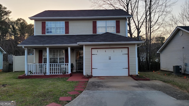 traditional home featuring covered porch, a front yard, central AC, a garage, and driveway