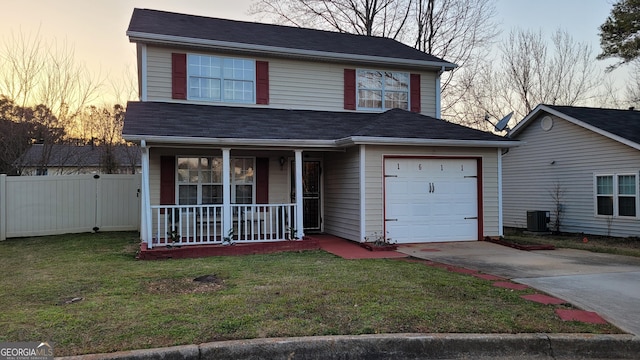 view of property featuring a lawn, central air condition unit, a porch, and a garage