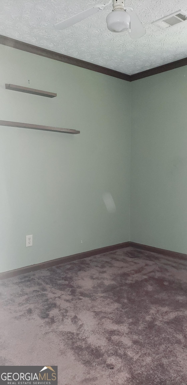 empty room featuring ornamental molding, visible vents, carpet flooring, and a textured ceiling