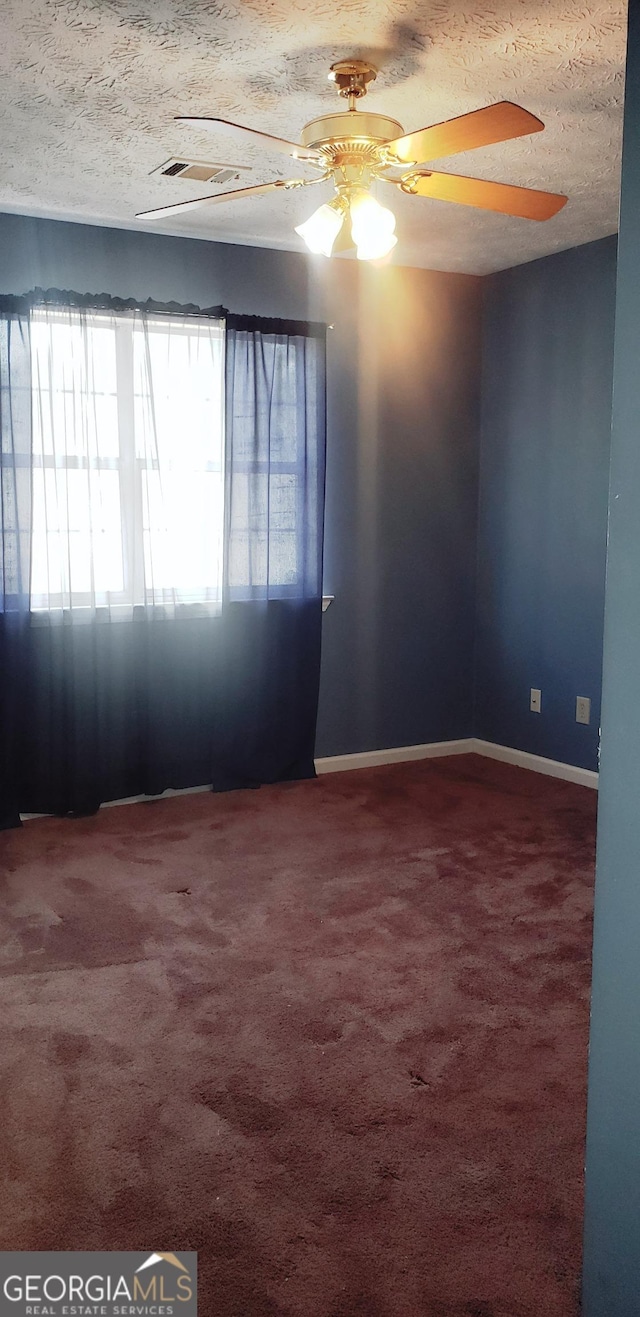 spare room featuring carpet floors, ceiling fan, baseboards, and a textured ceiling