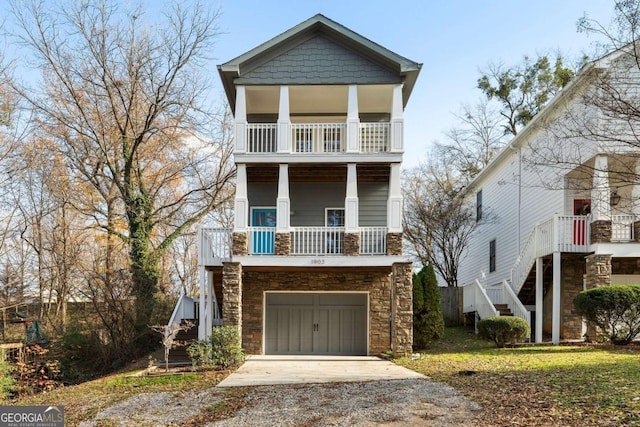 view of front of home featuring a balcony, a front lawn, and a garage