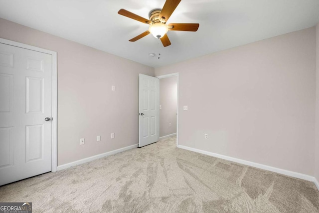 unfurnished bedroom featuring ceiling fan and light colored carpet