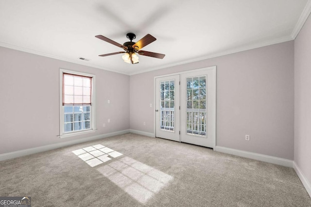 carpeted spare room with plenty of natural light, ceiling fan, and crown molding