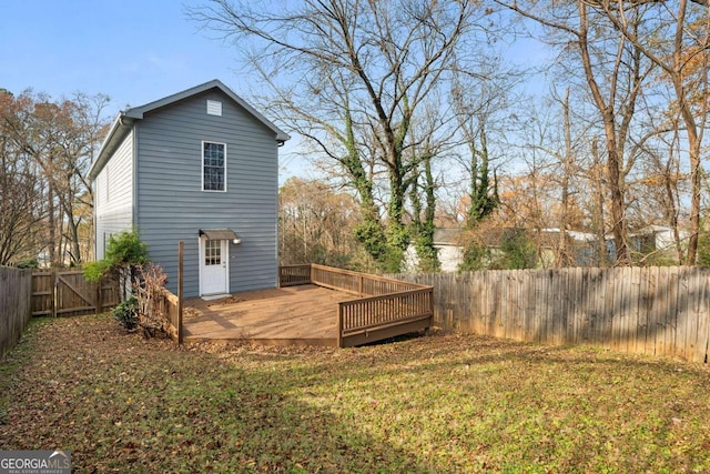 back of property with a yard and a deck