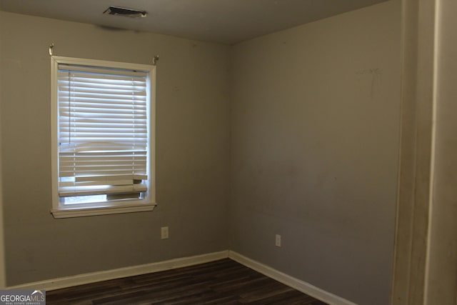 spare room featuring dark wood-type flooring