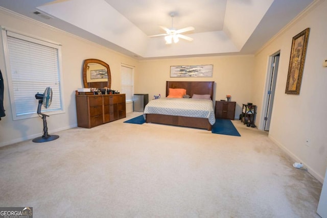 carpeted bedroom with a tray ceiling, ceiling fan, and ornamental molding