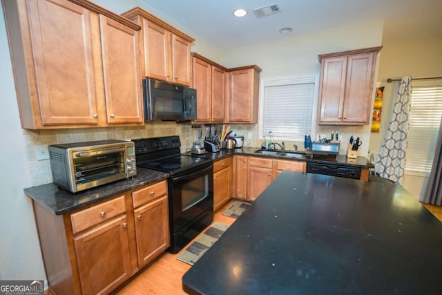 kitchen featuring decorative backsplash, sink, black appliances, and light hardwood / wood-style floors