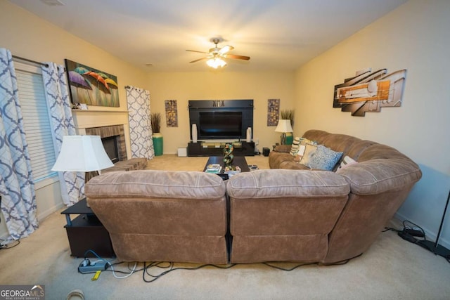 living room with carpet, a brick fireplace, and ceiling fan