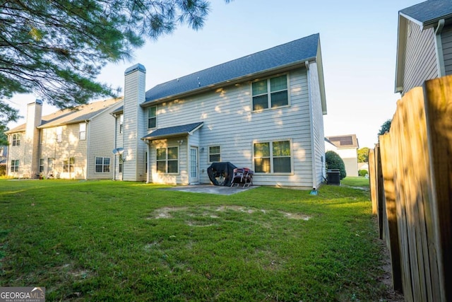 back of house featuring a lawn, a patio, and central AC unit