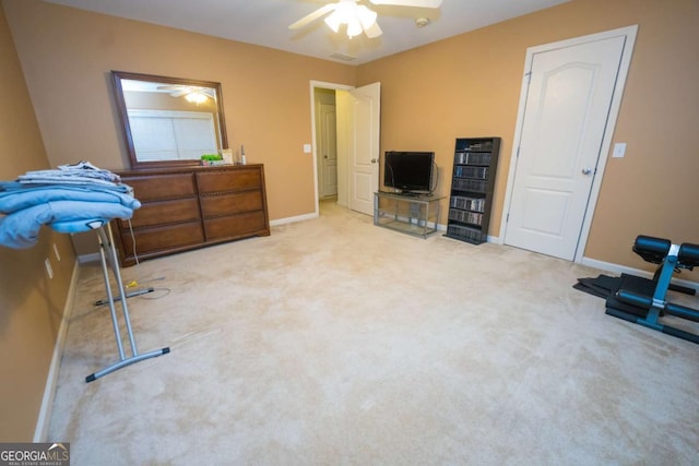 exercise area with ceiling fan and light colored carpet