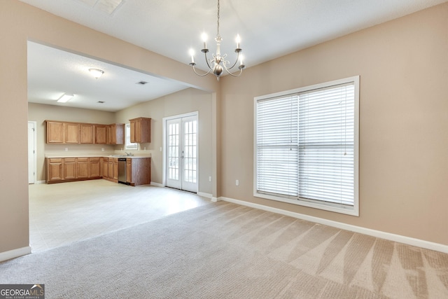 kitchen with dishwasher, sink, a chandelier, light colored carpet, and decorative light fixtures