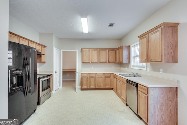 kitchen with appliances with stainless steel finishes, a textured ceiling, and sink