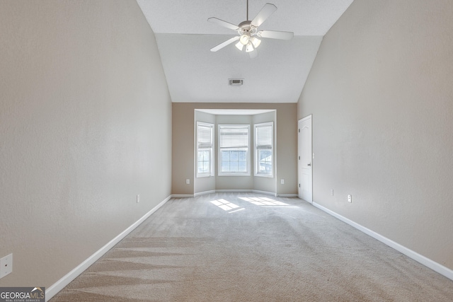 carpeted spare room with vaulted ceiling and ceiling fan