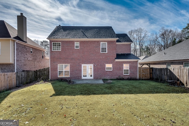 back of property with a lawn, a patio area, and french doors