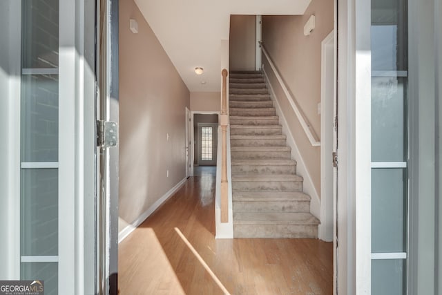 staircase with hardwood / wood-style flooring