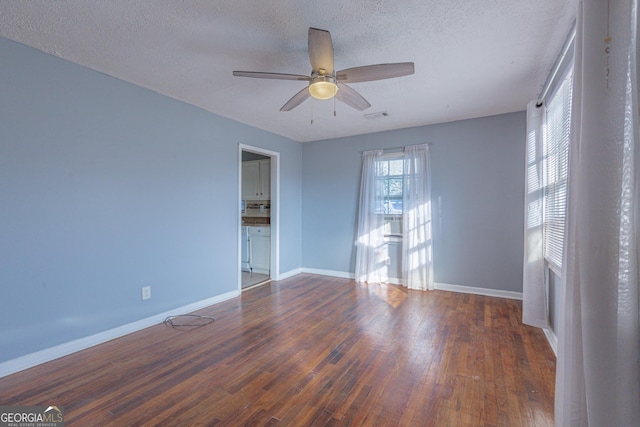 unfurnished room featuring dark hardwood / wood-style floors, ceiling fan, and a textured ceiling