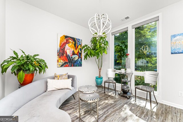 living area featuring hardwood / wood-style floors and an inviting chandelier