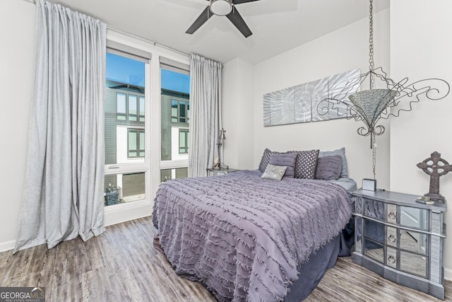 bedroom featuring multiple windows, a ceiling fan, and wood finished floors