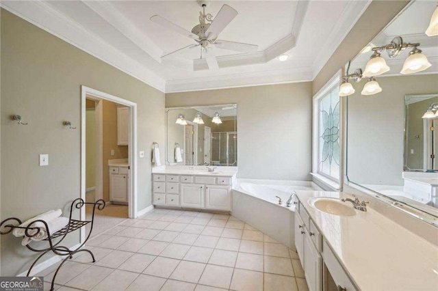 bathroom with ceiling fan, a raised ceiling, tile patterned flooring, crown molding, and vanity