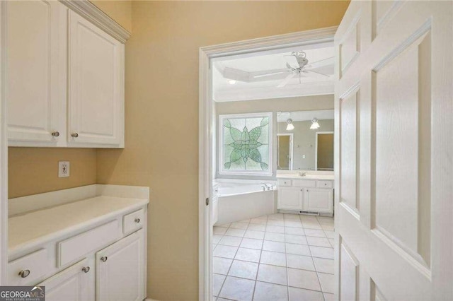 interior space featuring tile patterned flooring, vanity, a bathtub, and ceiling fan