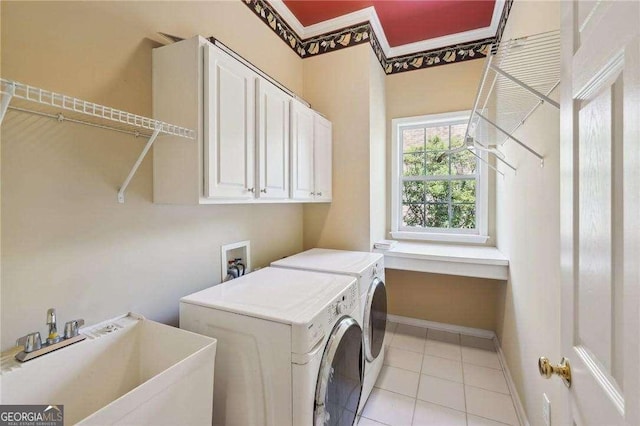 washroom featuring washing machine and dryer, sink, light tile patterned flooring, and cabinets