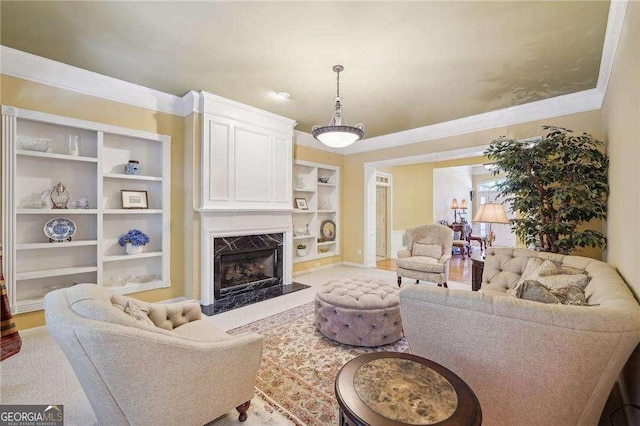 living room featuring built in features, a premium fireplace, and crown molding