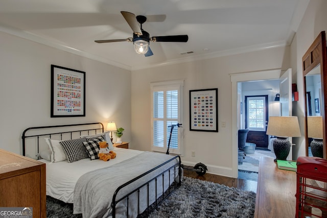 bedroom featuring multiple windows, ceiling fan, crown molding, and dark hardwood / wood-style floors