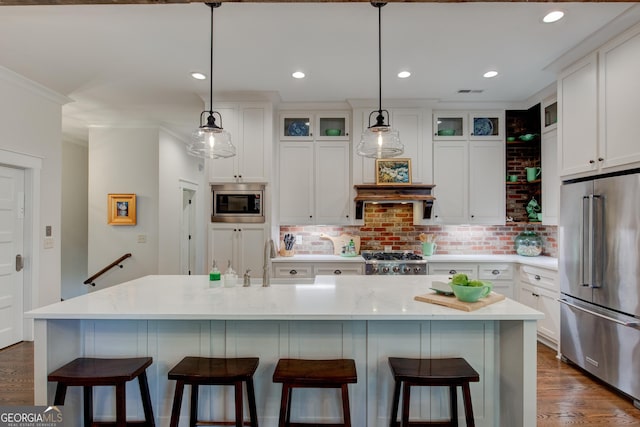 kitchen with white cabinets, appliances with stainless steel finishes, and a center island with sink