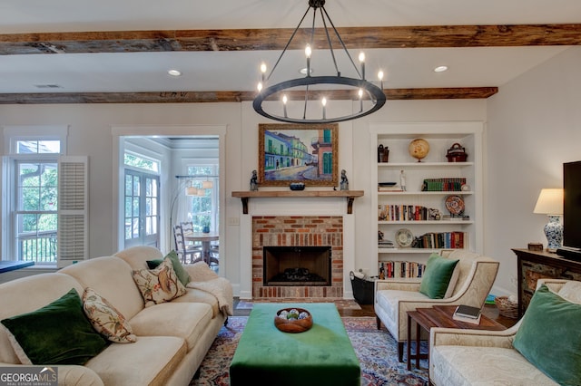 living room with a chandelier, beam ceiling, built in features, and a fireplace