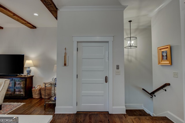 foyer entrance with beamed ceiling, dark hardwood / wood-style floors, and a notable chandelier