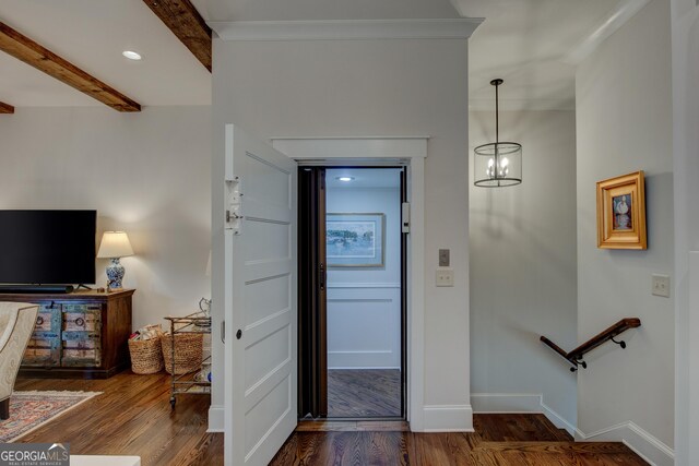 foyer featuring crown molding, beamed ceiling, a chandelier, and dark hardwood / wood-style floors