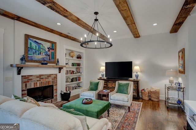 living room with built in shelves, dark hardwood / wood-style floors, a fireplace, beamed ceiling, and a chandelier