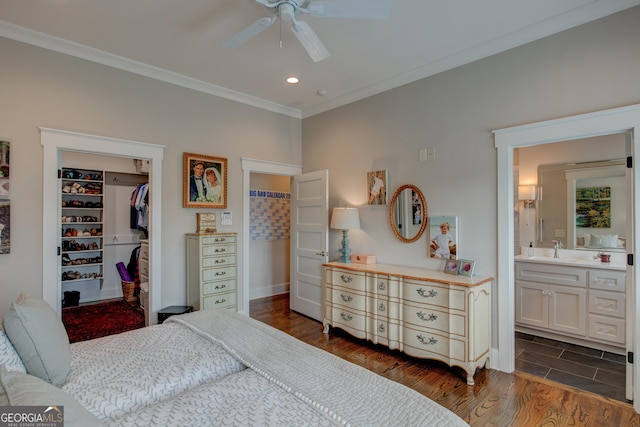 bedroom featuring ensuite bath, ceiling fan, a spacious closet, dark hardwood / wood-style flooring, and a closet